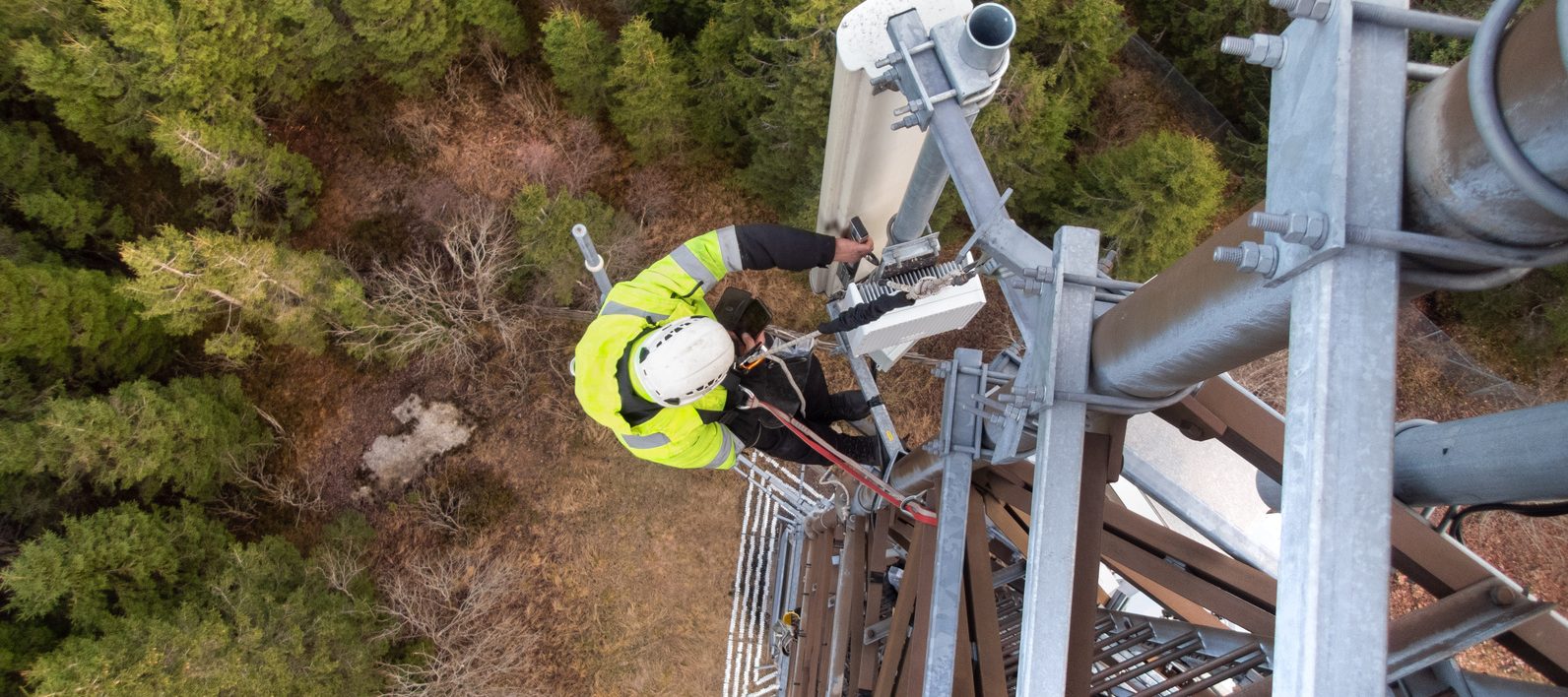 A technician on a telecommunication tower, 5G fiber optic antenna