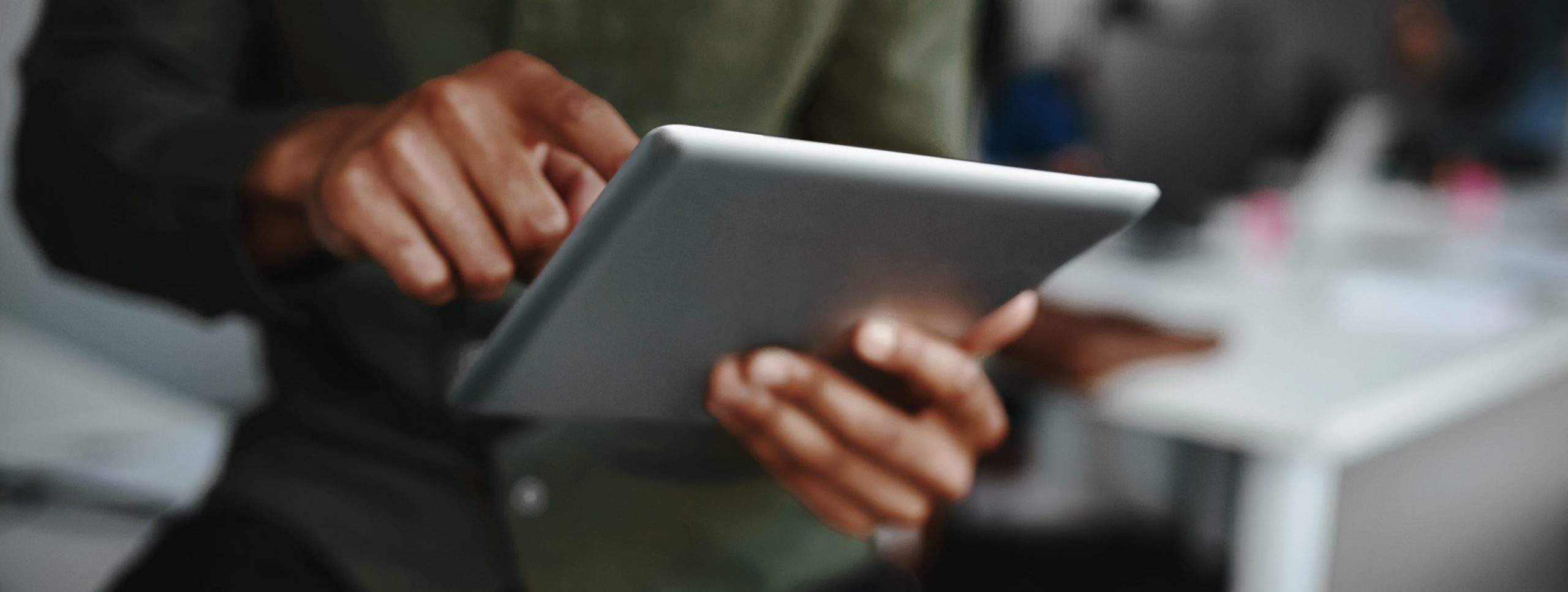 Close-up of businessman's finger touching screen of a digital tablet at the office
